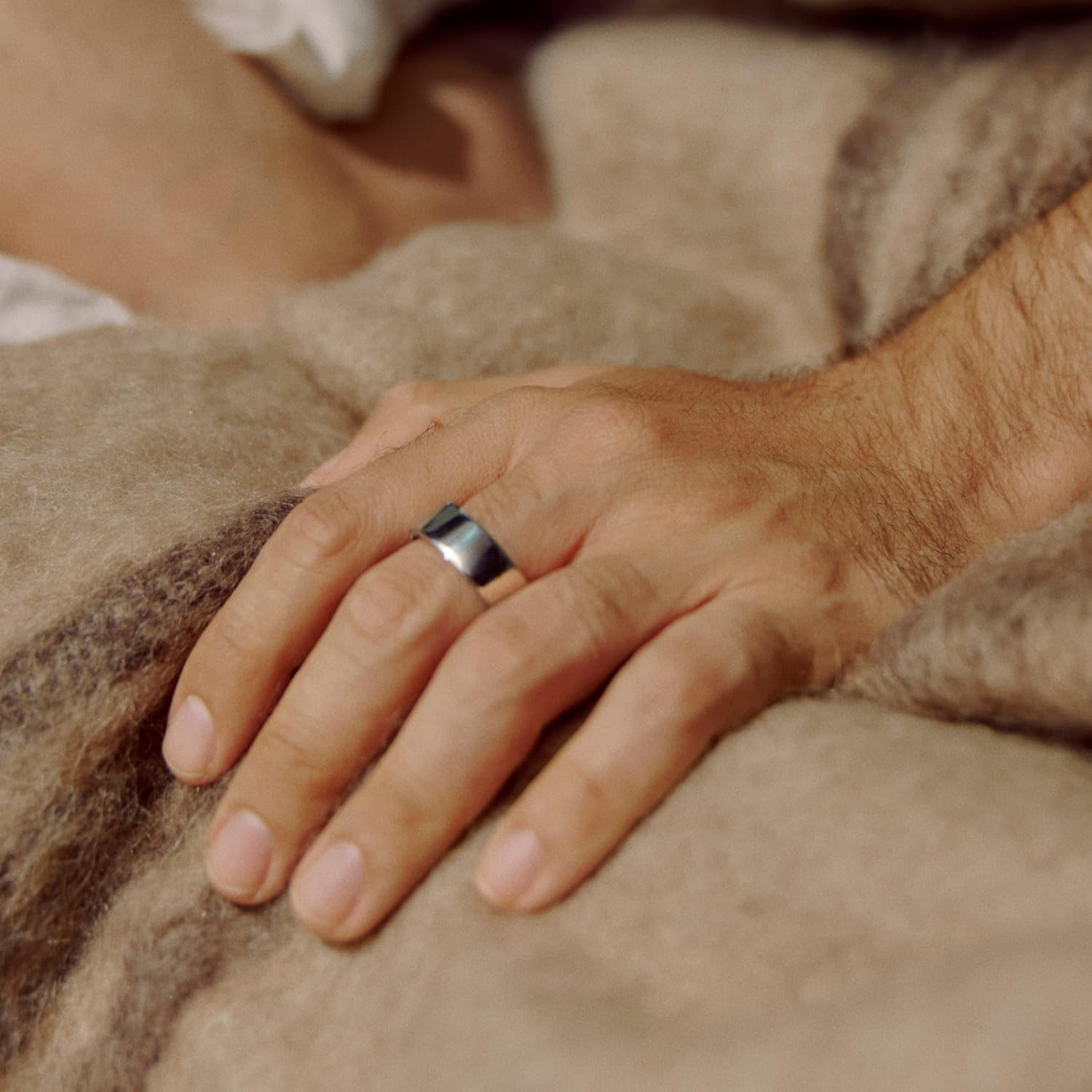 Homme portant l'Oura Ring 4 à la main, au repos — bague fine et discrète portée au quotidien